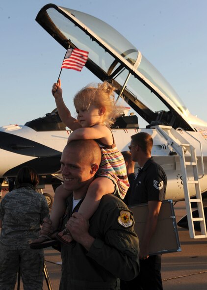 DYESS AIR FORCE BASE, Texas -  Abilene Police Officer Andy Adkins holds his two year old daughter, Addison, after his flight with the Thunderbirds here, April 29. The Hometown Hero program is designed to showcase Abilenians putting forth amazing effort in their community, in line with amazing efforts put forth by America's Airman every day. Officer Adkins received community recognition when he volunteered his time and service to provide a unique opportunity for a special needs individual in the community. (U.S. Air Force photo/ Airman 1st Class Cheslea Browning)