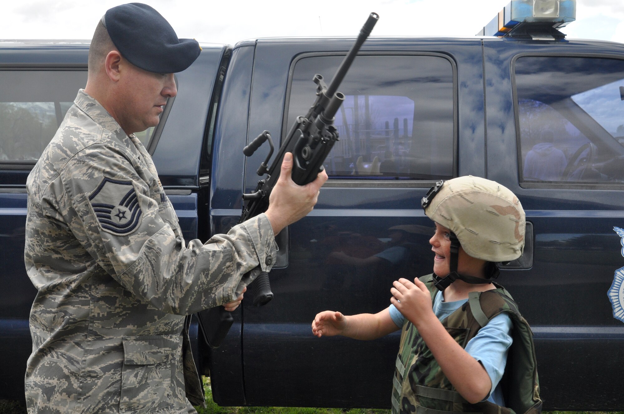 Master Sgt. John Millaway, combat arms instructor in the 419th Security Forces Squadron, hands a demonstration weapon to Jaden Spendlove, one of the many visitors at the419th Fighter Wing’s Family Day May 2. (U.S. Air Force photo/ Staff Sgt. Heather Skinkle)