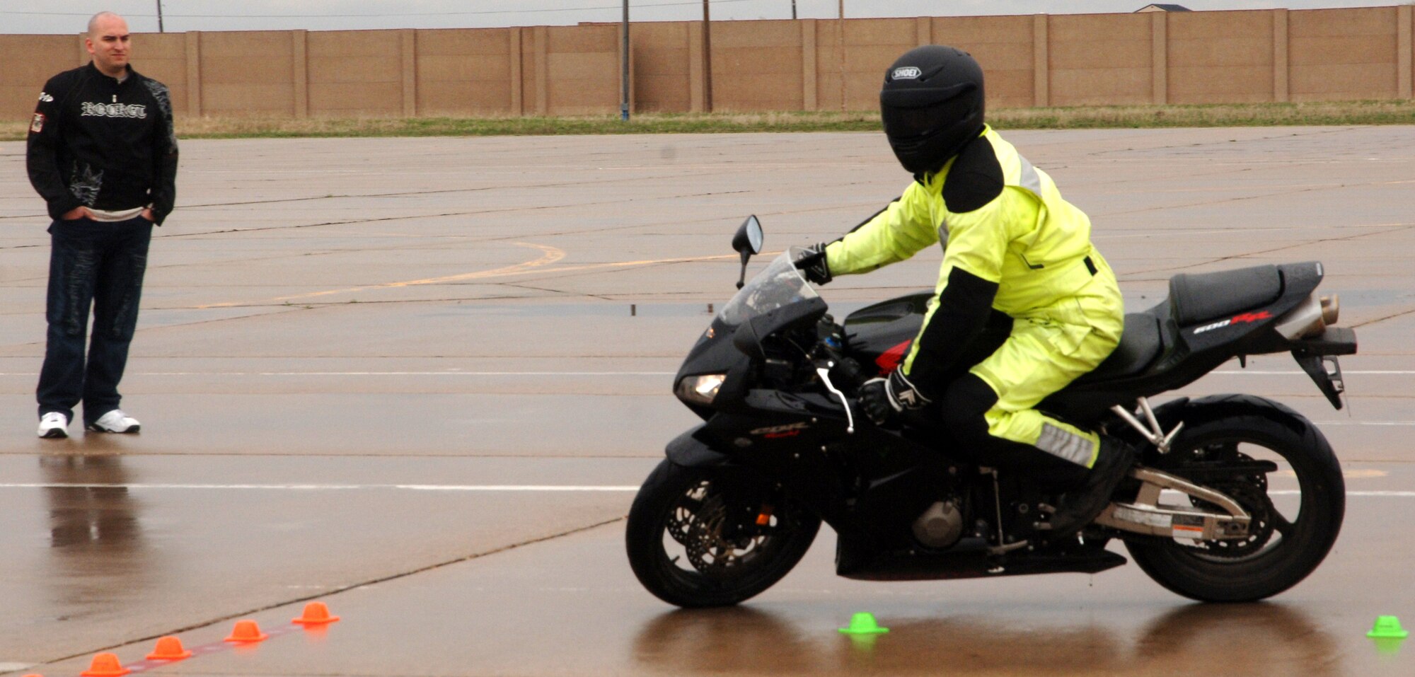 Staff Sgt. Joel Rodriguez, 319th Maintenance Operations Squadron, observes Capt. Ryan Peterson, 905th Air Refueling Squadron and instructor for the Air Mobility Command Sport Bike Course, execute a sharp turn on the sport bike safety training course April 30 at Grand Forks Air Force Base, N.D. The safety training course is part of the Air Mobility Command Sport Bike Course, which is a requirement for all military (on and off the installation) and Department of Defense civilians (while on the installation) to operate a sport bike while assigned to an AMC unit. The training is an all day event and once certified the operator will remain certified for as long as they are assigned to an AMC unit or unless otherwise directed. (U.S. Air Force photo by Airman 1st Class Rachel Martinez)