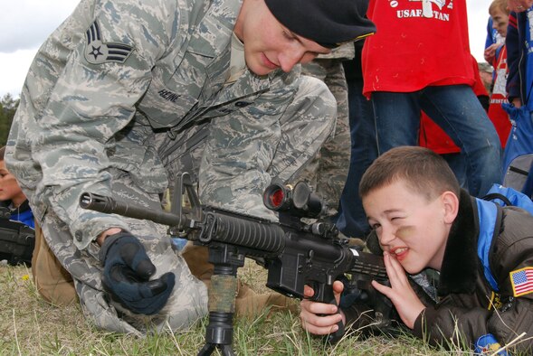 Senior Airman Jacob Heine familiarizes Andy Miller with an M-4 rifle during Operation Junior Deployer at the Air Force Academy May 1, 2010. Airman Heine is a patroller with the Academy's 10th Security Forces Squadron. (U.S. Air Force photo/Staff Sgt. Don Branum)