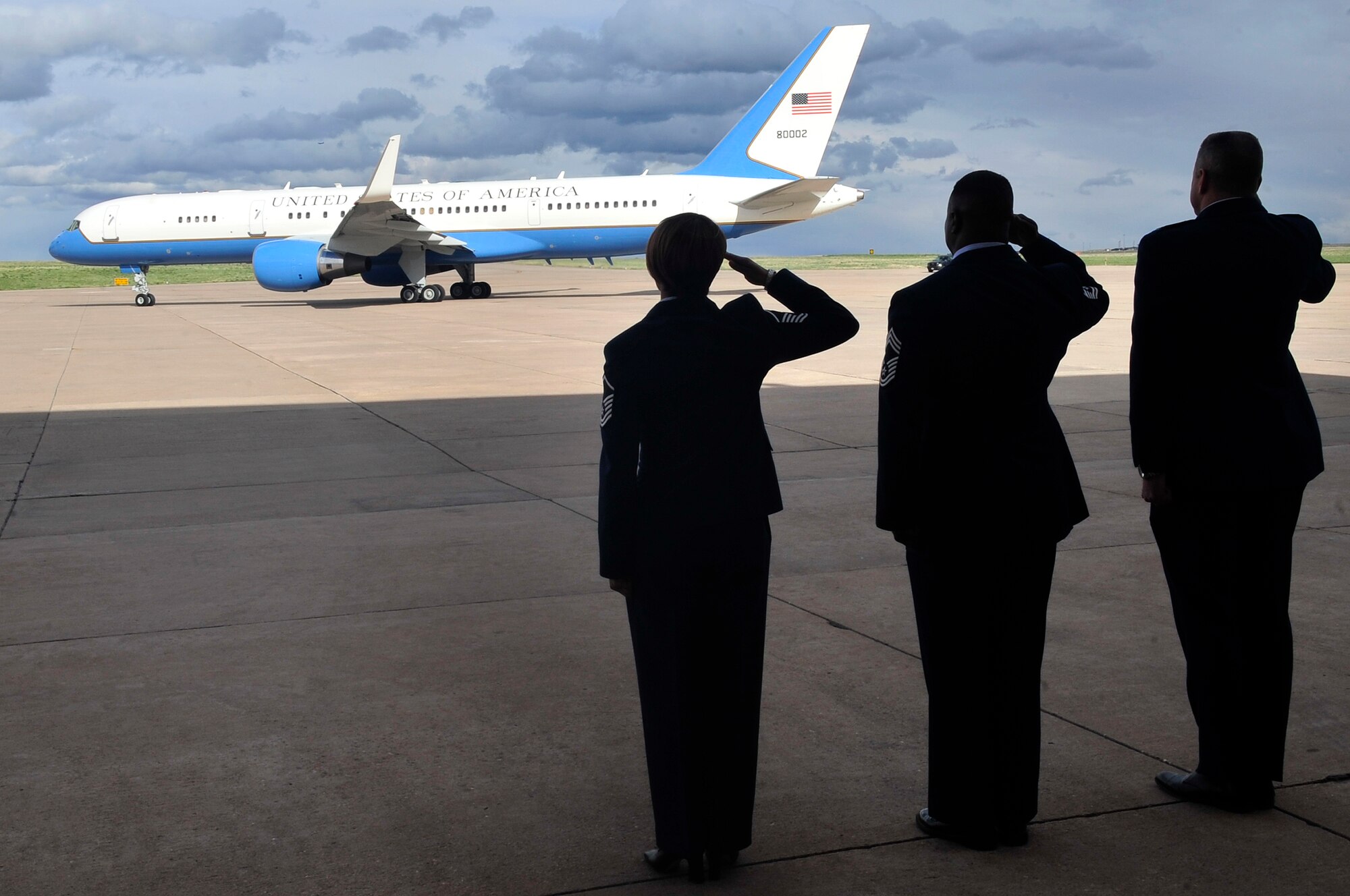BUCKLEY AIR FORCE BASE, Colo. -- Col. Trent Pickering, 460th Space Wing vice commander, Chief Master Sgt. Gregory Williams, acting 460th SW command chief, and Master Sgt. DeRinda Johnson, 460th SW staff first sergeant, all salute Air Force Two as it departs with Vice President Joe Biden and his wife, Jill, from Buckley Air Force Base April 30. (U.S. Air Force Photo By Airman 1st Class Manisha Vasquez)