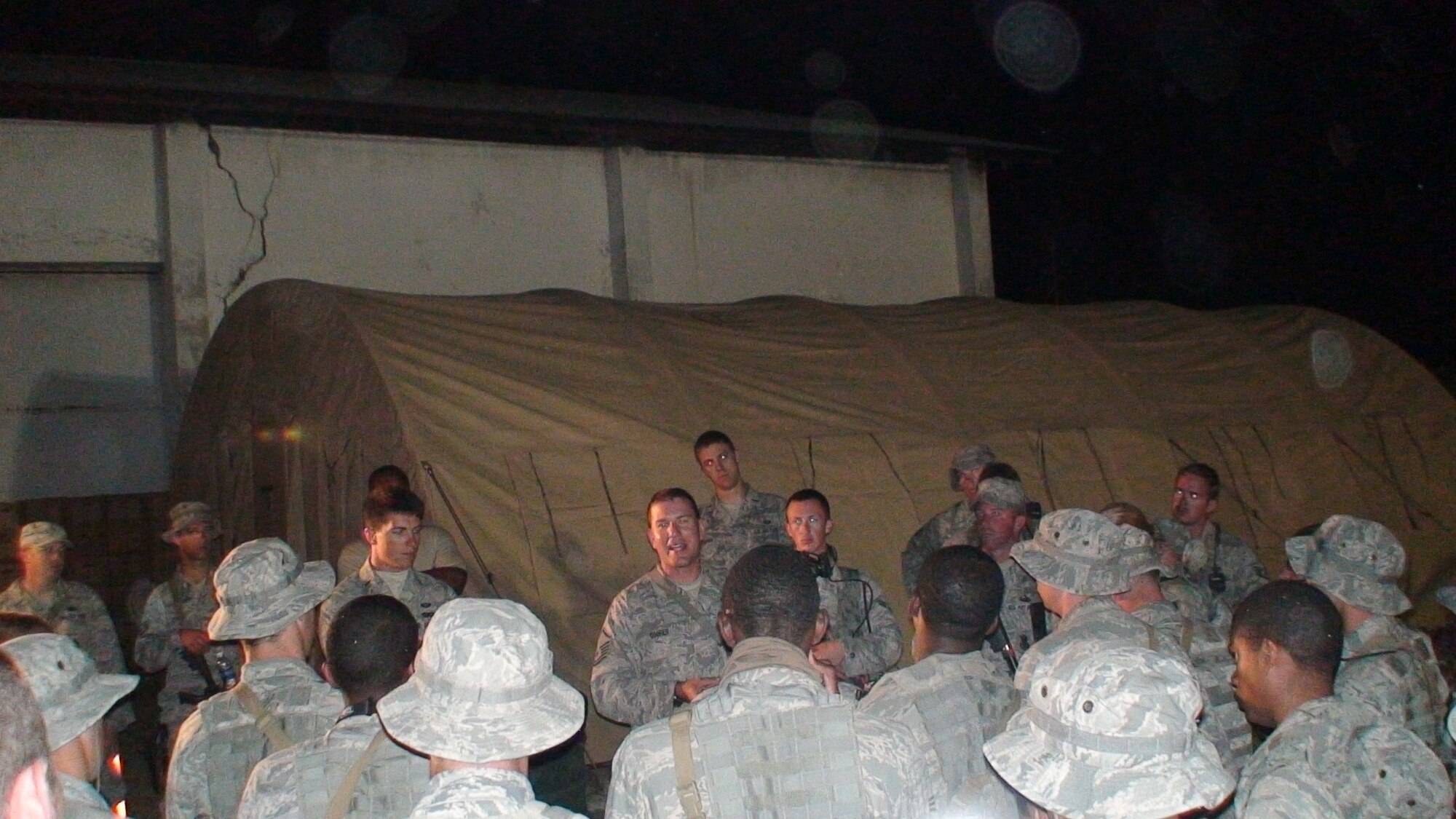 PORT-AU-PRINCE, Haiti -- Master Sgt. Todd Cooper, 823rd Expeditionary Security Forces Squadron flight sergeant, briefs his troops before a shift change in Port-au-Prince, Haiti. Eight years ago, Sergeant Cooper was part of the team that conducted exercises to best determine ways to open and operate bare bases in remote locations. (Contributed photo/RELEASED)