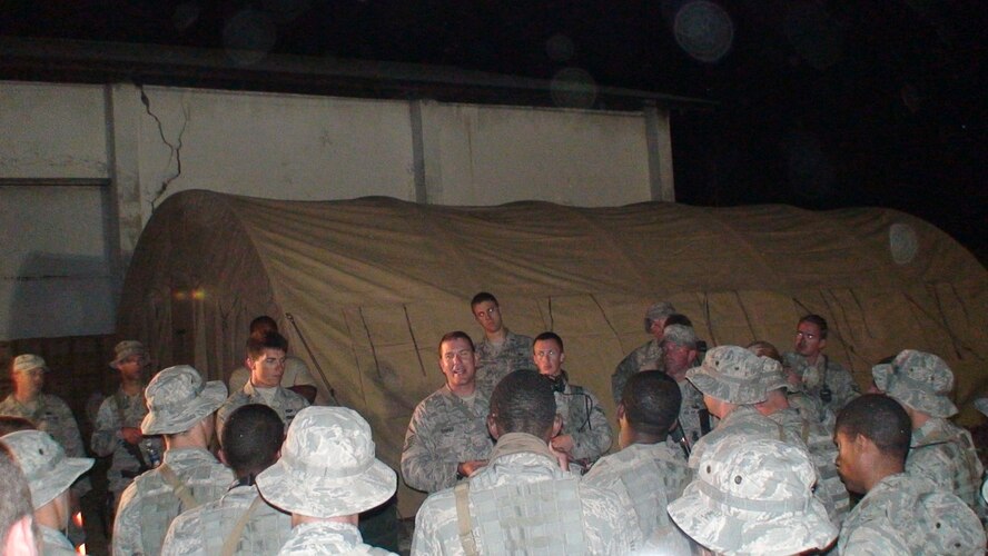 PORT-AU-PRINCE, Haiti -- Master Sgt. Todd Cooper, 823rd Expeditionary Security Forces Squadron flight sergeant, briefs his troops before a shift change in Port-au-Prince, Haiti. Eight years ago, Sergeant Cooper was part of the team that conducted exercises to best determine ways to open and operate bare bases in remote locations. (Contributed photo/RELEASED)