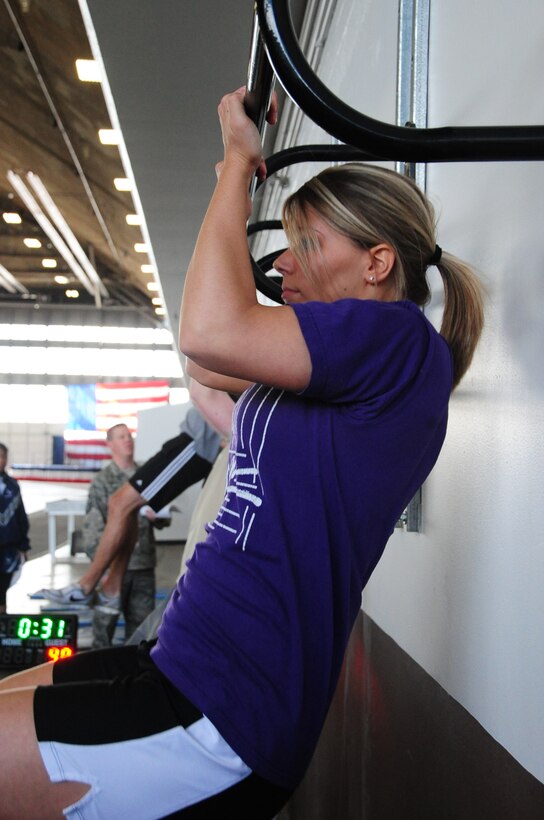 ELLSWORTH AIR FORCE BASE, S.D. – Alesia Randolph, wife of Airman 1st Class James Randolph, 28th Comptroller Contracting Squadron contract administrator, does pull-ups in competition with three other teams, April 29.  The pull-up event was part of the quarterly Iron Flight competition where Mrs. Randolph’s team took 1st place. (U.S. Air Force photo/Airman 1st Class Anthony Sanchelli)