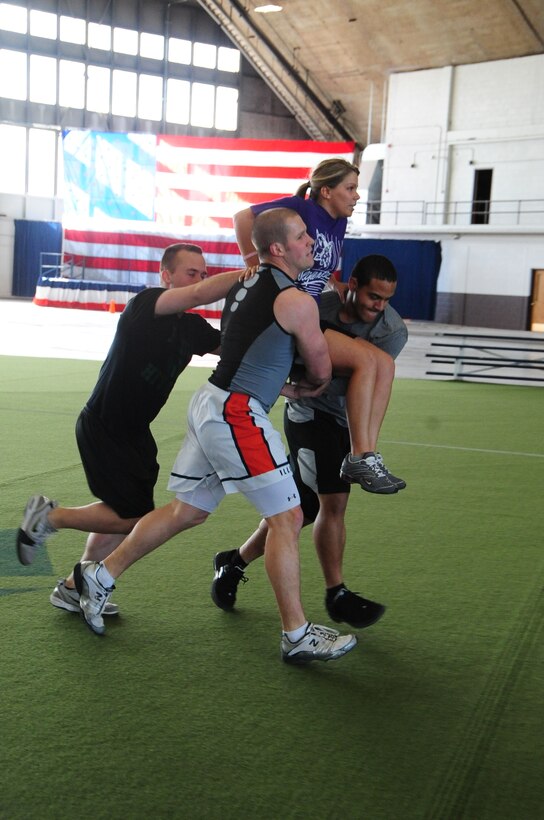 ELLSWORTH AIR FORCE BASE, S.D. – (Left to right) Airman 1st Class James Randolph, 28 Comptroller Contracting Squadron contract administrator, 2nd Lt. Austin Dowling, 28 CCS financial analyst and 2nd Lt. Richie Amisone, 28 CCS financial service officer, hold Alesia Randolph, wife of Airman 1st Class Randolph during a seat carry event, April 29.  The competing teams carried one of their teammates across a soccer field and back, twice, during the quarterly Iron Flight competition. (U.S. Air Force photo/Airman 1st Class Anthony Sanchelli)