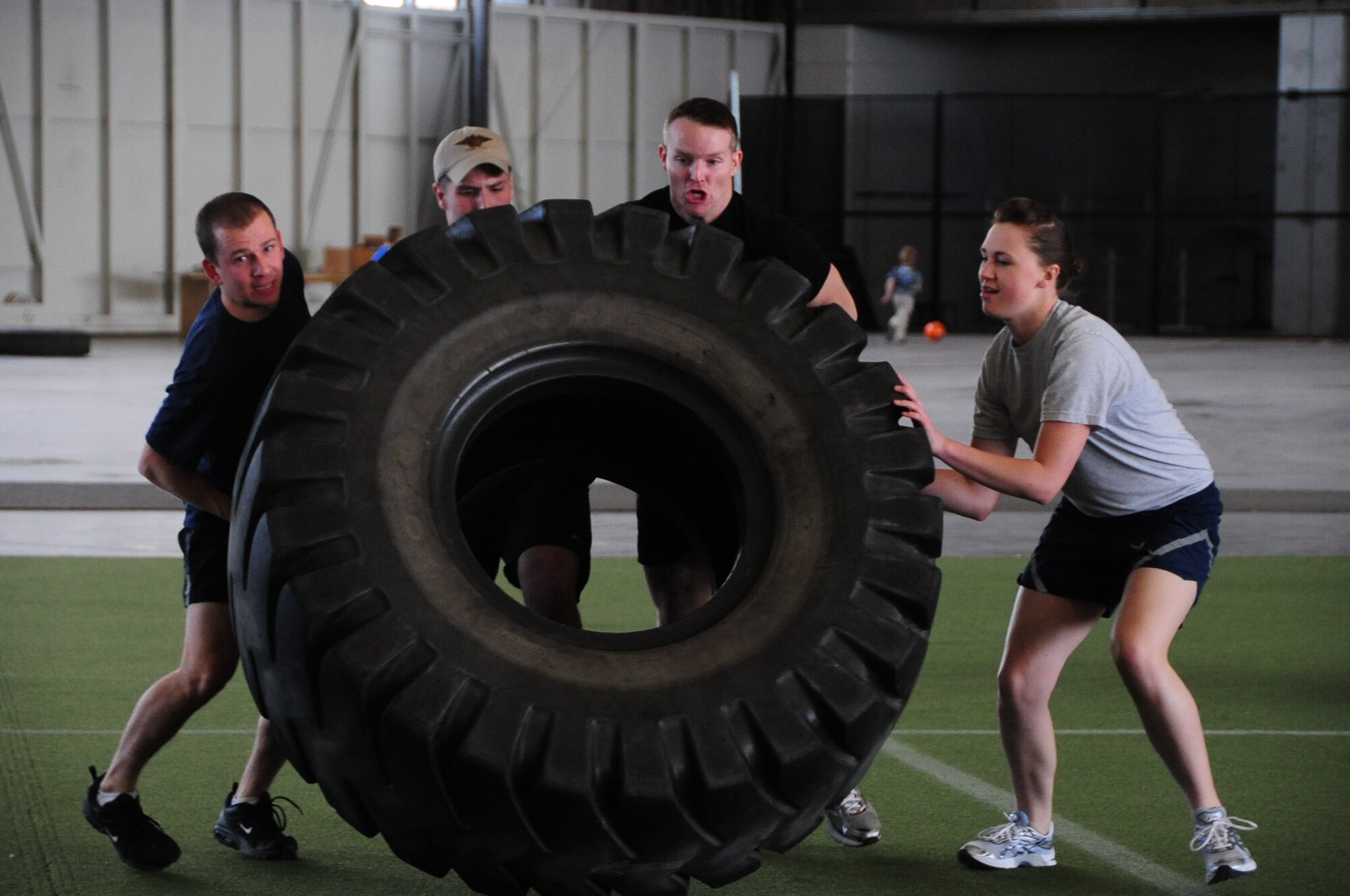 ELLSWORTH AIR FORCE BASE, S.D. – (Left to right) Capt. Todd Patterson, 28th Operations Support Squadron flight commander, Senior Airman Zachary Yoakam, 28th Operations Group survival, evasion, resistance and escape specialist, Staff Sgt. Brandon Dunphy, 28 OG SERE NCO in-charge and Airman 1st Class Alison Meyer, 28 OG intelligence analyst, work together in a tire flip event, April 29.  The tire-flip event was part of the quarterly Iron Flight competition where this team took 2nd place. (U.S. Air Force photo/Airman 1st Class Anthony Sanchelli)