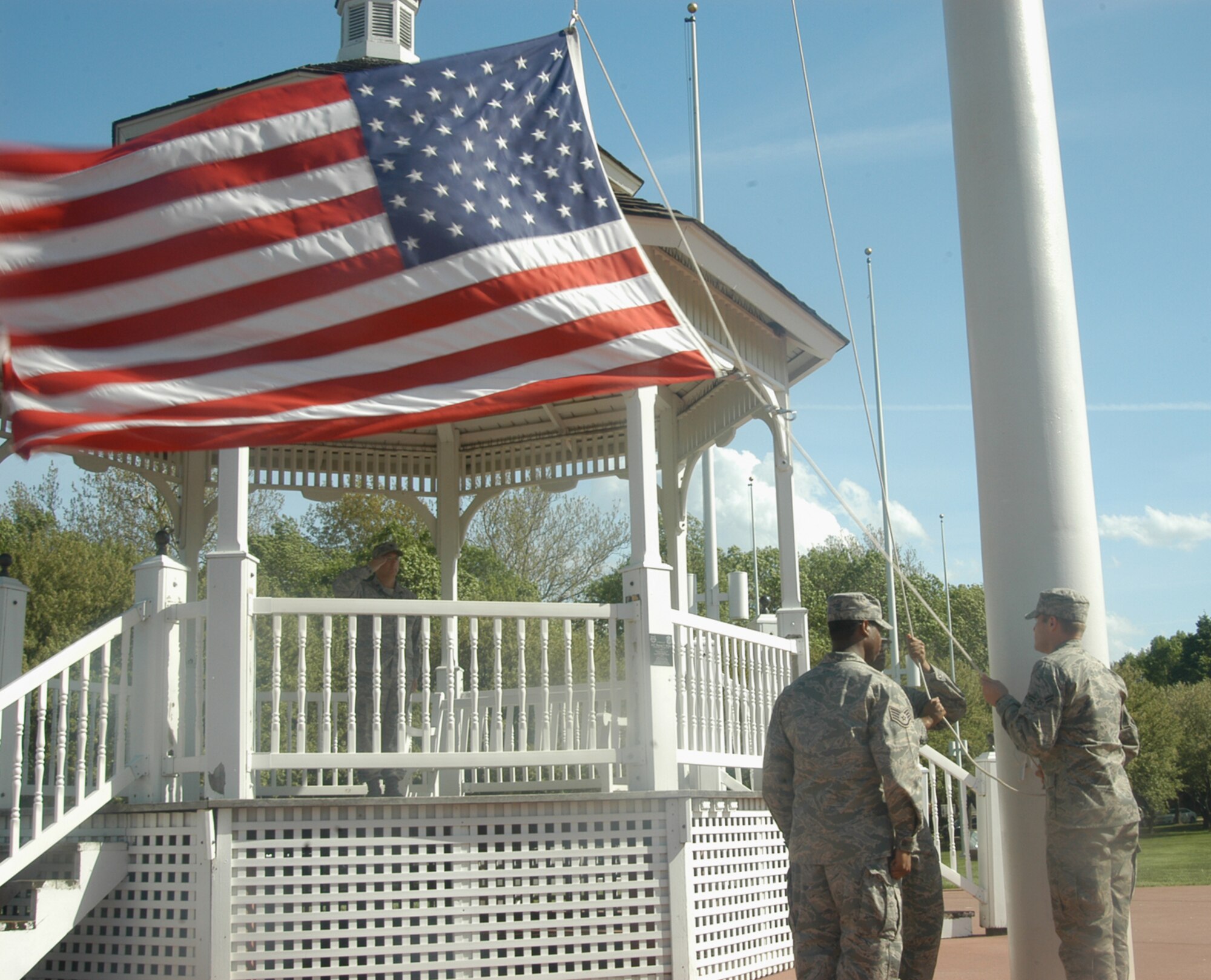 OFFUTT AIR FORCE BASE, Neb. -- Airman 1st Class Darius T. Dinkins and Airman 1st Class Dylan Brown, both with the 55th Comptroller Squadron, lower the American flag while Lt. Col. Allen D. Simpson, 55th CPTS commander, renders a salute and Staff Sgt. Julius McCray, also with the 55th CPTS and the leader of the flag detail looks on, during a retreat ceremony at the parade grounds here April 29. The ceremony signifies the end of the duty day. U.S. Air Force photo by Staff Sgt. James M. Hodgman            