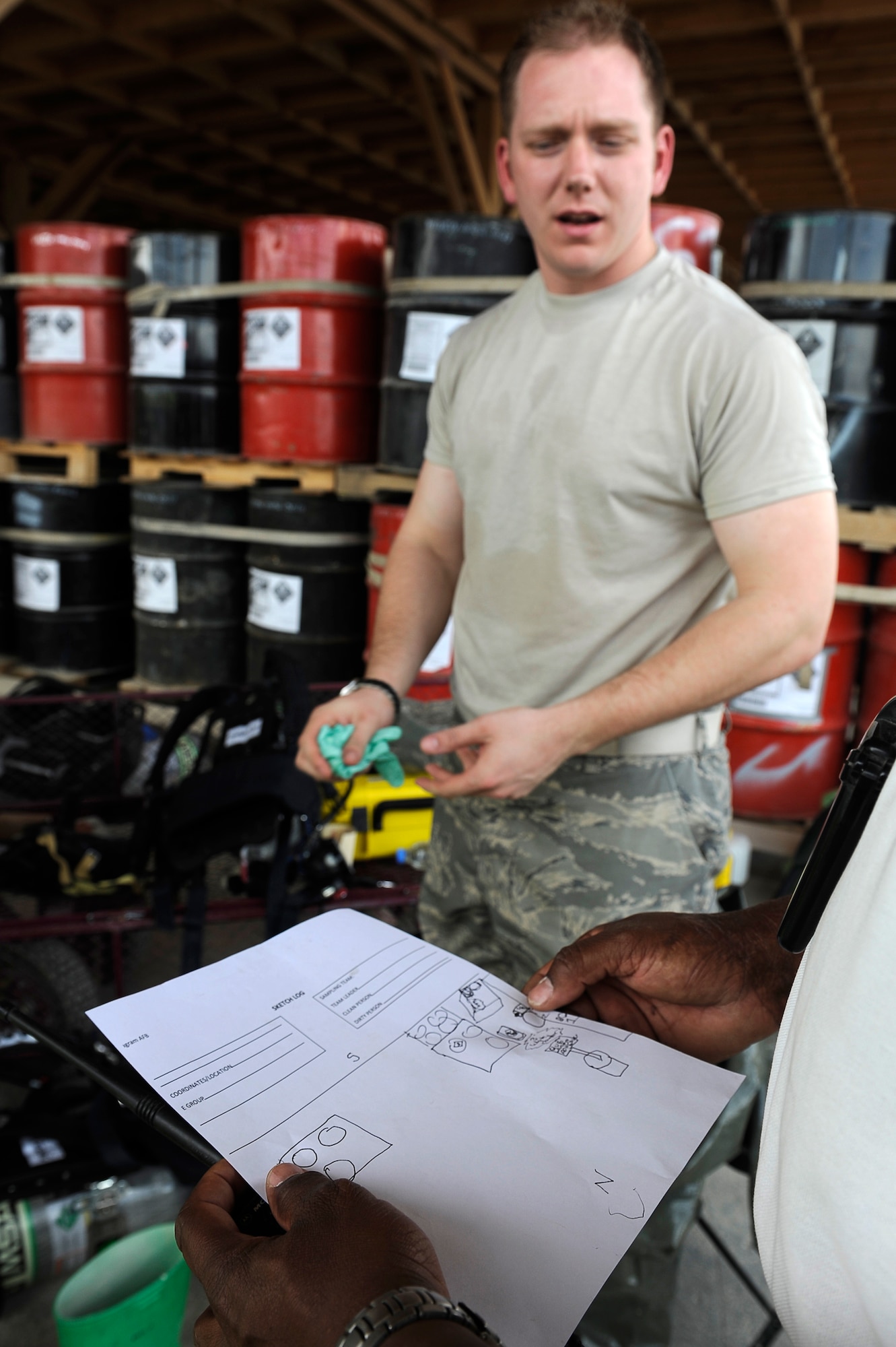 U.S. Air Force Senior Airman Michael Gilbert, 455th Expeditionary Medical Operations Squadron, describes the chemical spill location to an exercise evaluator during a hazardous materials exercise at Bagram Airfield, Afghanistan, April 29, 2010. Airman Gilbert is deployed from Nellis Air Force Base, Nev., and is from Exeter, Calif. (U.S. Air Force photo by/ Master Sgt. Jeromy K. Cross/released)