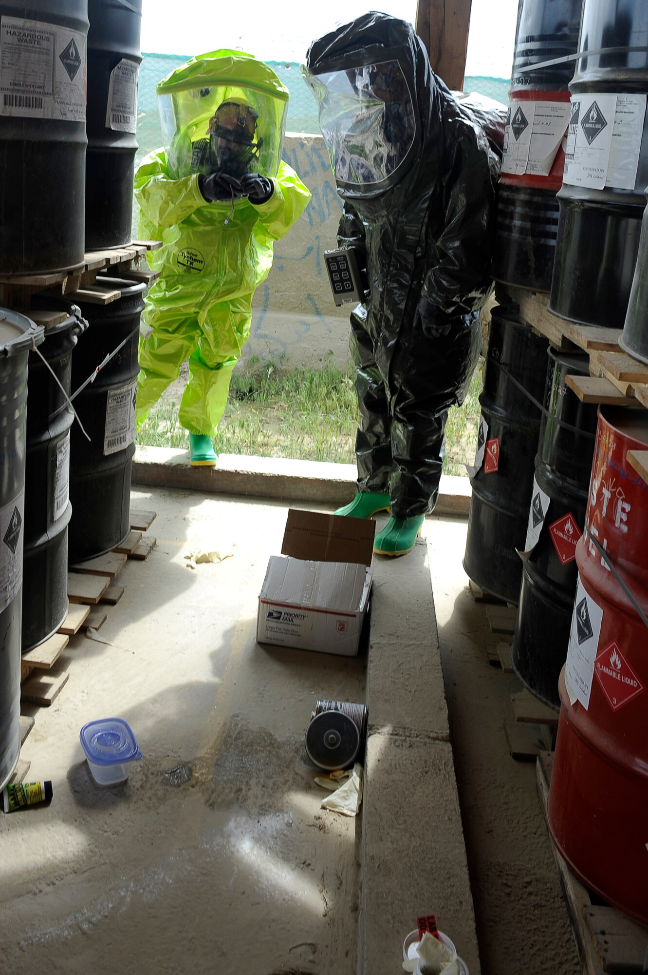 U.S. Air Force Senior Airman Michael Gilbert (green suit), 455th Expeditionary Medical Operations Squadron, Staff Sgt. Gabrial Karnav, 455th Expeditionary Civil Engineer Squadron, examine the spill site during a hazardous materials exercise at Bagram Airfield, Afghanistan, April 29, 2010. Airman Gilbert is deployed from Nellis Air Force Base Nev., and is from Exeter, Calif. Sergeant Karnav is deployed from the Minnesota National Guard, and is from Ironwood, Mich.(U.S. Air Force photo by/ Master Sgt. Jeromy K. Cross/released)