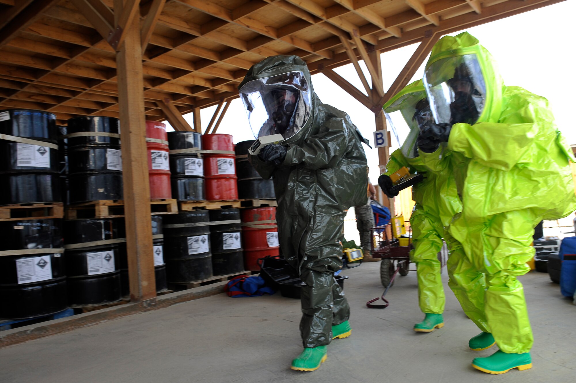 U.S. Air Force Senior Airman Michael Gilbert (green suit), 455th Expeditionary Medical Operations Squadron, Staff Sgts. Gabrial Karnav, and Alicia Lagarde, 455th Expeditionary Civil Engineer Squadron, walk to the exercise spill in their chemical protection suit during a hazardous materials exercise at Bagram Airfield, Afghanistan, April 29, 2010. Airman Gilbert is deployed from Nellis Air Force Base, Nev., and is from Exeter, Calif. Sergeants Karnav and Lagarde are deployed from the Minnesota Air National Guard, Sergeant Karnav is from Ironwood, Mich., and Sergeant Lagarde is from Wrenshall, Minn. (U.S. Air Force photo by/ Master Sgt. Jeromy K. Cross/released)