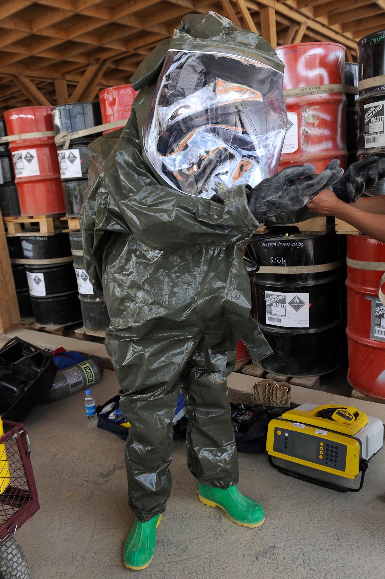 U.S. Air Force Senior Airman Michael Gilbert, 455th Expeditionary Medical Operations Squadron, puts on a chemical protection suit during a hazardous materials exercise at Bagram Airfield, Afghanistan, April 29, 2010. Airman Gilbert is deployed from Nellis Air Force Base, Nev., and is from Exeter, Calif. (U.S. Air Force photo by/ Master Sgt. Jeromy K. Cross/released)