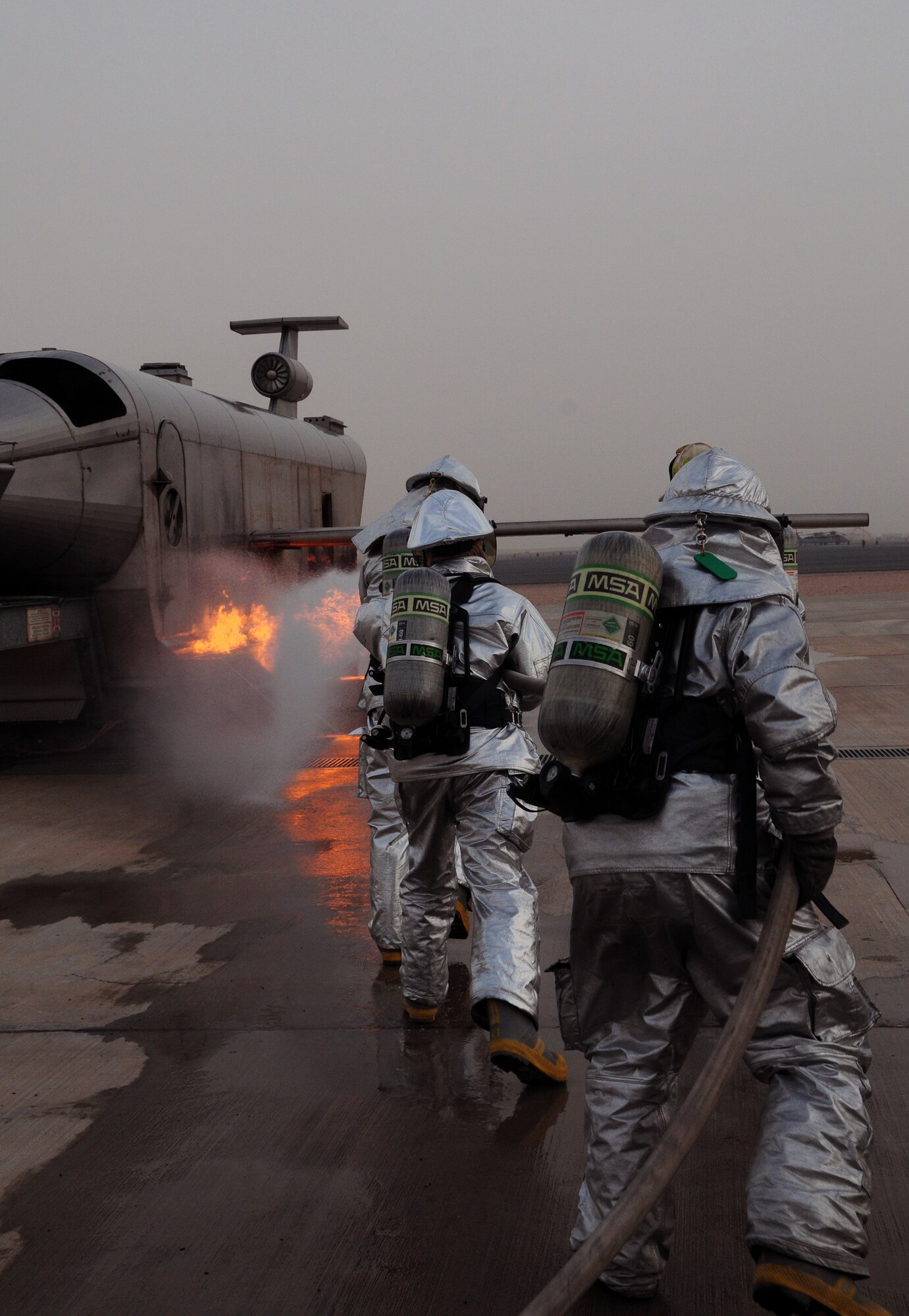 U.S. Air Force firefighters with the 386th Expeditionary Civil Engineer Squadron practice extinguishing an aircraft fire at a nearby base in Southwest Asia April 29, 2010. Live fire training is an annual requirement all U.S. Air Force firefighters must complete in order to stay proficient. (U.S. Air Force photo by Staff Sgt. Lakisha A. Croley/Released)