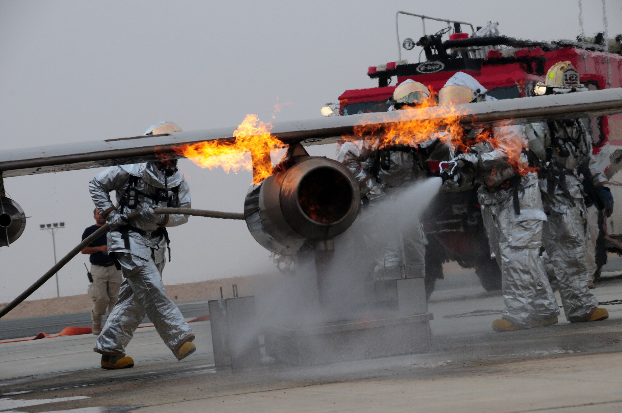 U.S. Air Force firefighters with the 386th Expeditionary Civil Engineer Squadron rush to the scene of a burning aircraft during live fire training at a nearby base in Southwest Asia April 29, 2010. Live fire training is an annual requirement all firefighters must complete in order to stay proficient. (U.S. Air Force photo by Staff Sgt. Lakisha A. Croley/Released)