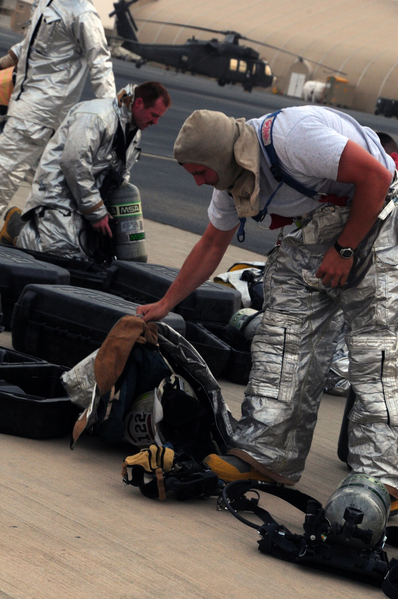 From left, U.S. Air Force Senior Airman Aric Baker and Master Sgt. Jake Blair, 386th Expeditionary Civil Engineer Squadron firefighters, gear up and function check their equipment in preparation for live fire training at a nearby base in Southwest Asia April 29, 2010. The fire team consists of several Air Force Guard units stationed across the United States. (U.S. Air Force photo by Staff Sgt. Lakisha A. Croley/Released)