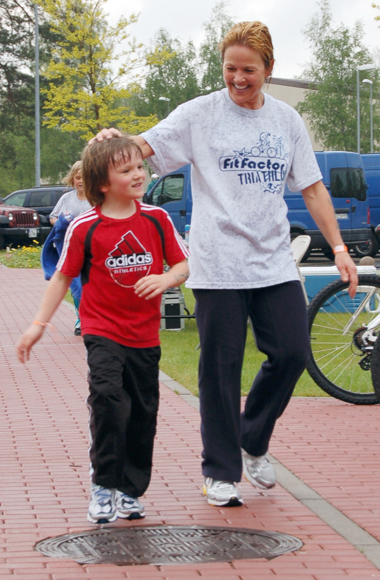 Laura Mitvalsky (right), U.S. Army Public Health Command, congratulates her son Eric Echtermeyer, 6, after completing the running portion of the second annual FitFactor Triathlon, Ramstein Air Base, Germany, May 2, 2010. Ms. Mitvalsky and her two children called themselves "Team FIT" (family in training) and each competed in a different portion of the event. (U.S. Air Force photo by Senior Airman Amanda Dick)