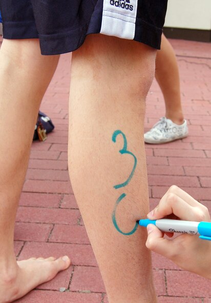 A volunteer marks the registration number on a participant of the second annual FitFactor Triathlon, Ramstein Air Base, Germany, May 2, 2010. Numbers were used to determine each participants overall time. (U.S. Air Force photo by Senior Airman Amanda Dick)