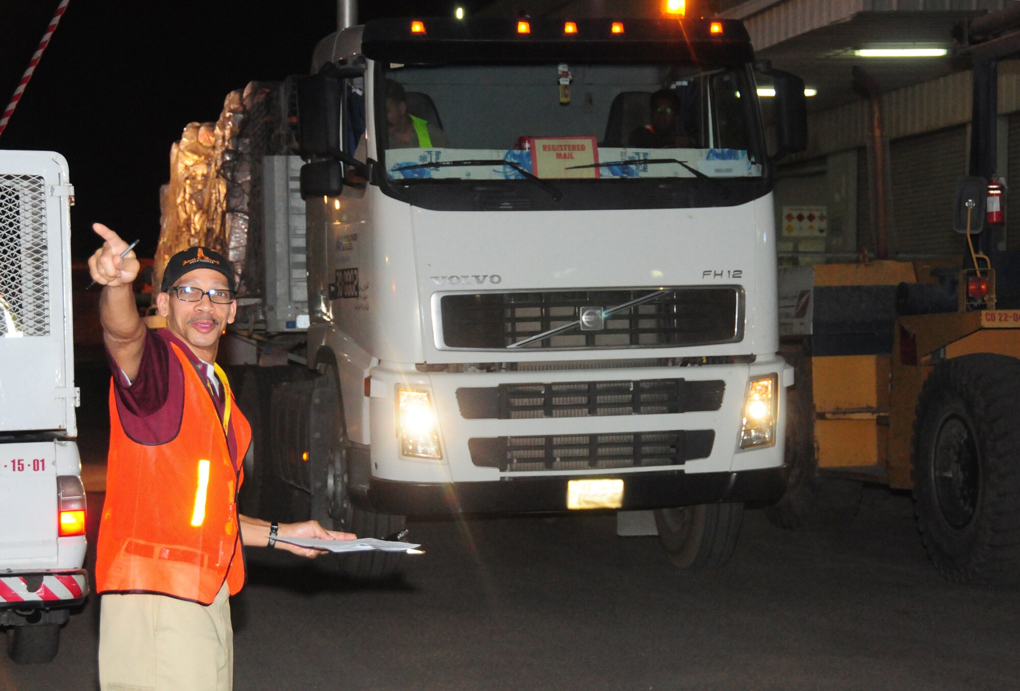 U.S. Air Force Tech. Sgt. Cornelious Barnett, 386th Expeditionary Communications Squadron mail control activity, directs contract drivers where to take pallets of outgoing U.S. mail in order to weigh it before flight April 27, 2010 at an undisclosed location in Southwest Asia. Sergeant Barnett is an Oklahoma City native deployed from the 72nd Aerial Port Squadron, Tinker Air Force Base, Okla. (U.S. Air Force photo illustration by Staff Sgt. Lakisha A. Croley/Released)