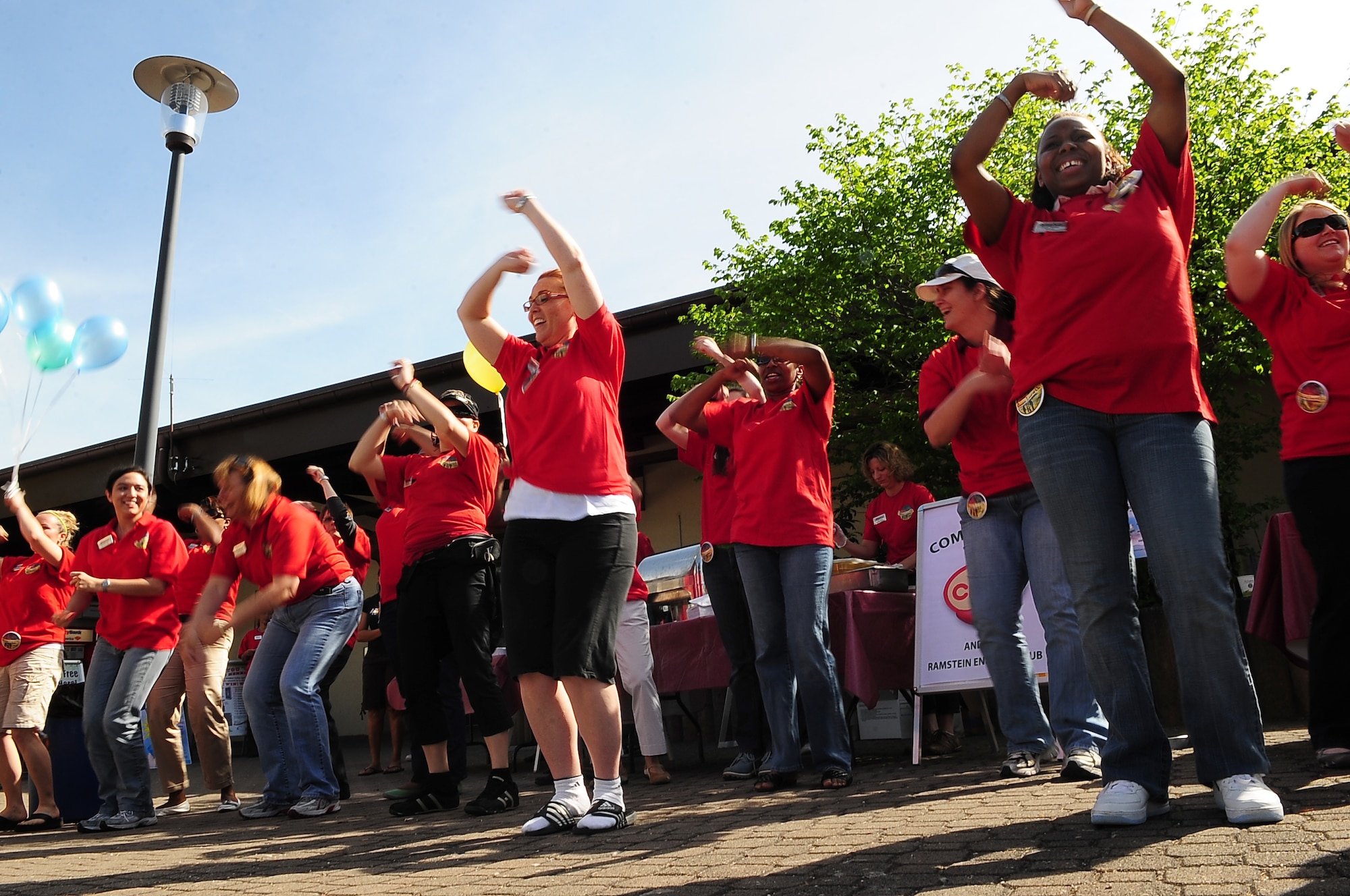 Volunteers join in a dance during a community event hosted by the 86th Services Squadron outside of the Northside Post Office, Ramstein Air Base, Germany, April 29, 2010. More than 150 members of the squadron volunteered their day setting up food booths, face-painting stands and a bouncy castle at the event to simply show gratitude to the community. (U.S. Air Force photo by Senior Airman Tony R. Ritter)