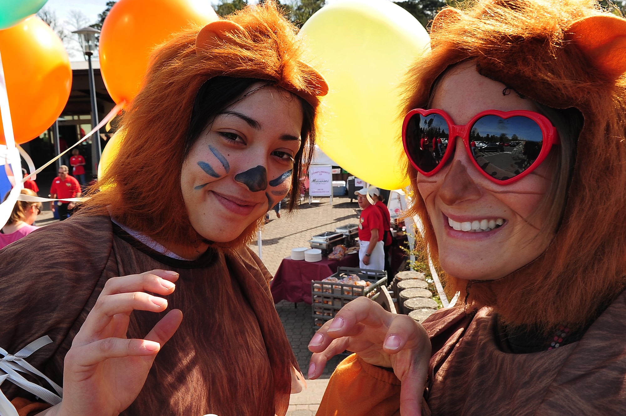 U.S. Air Force Airman 1st Class Cindy Valadez (left) and Senior Airman Tressa Planeta, 86th Services Squadron, dress as playful lions to entertain kids during a community event hosted by the 86th Services Squadron outside of the Northside Post Office, Ramstein Air Base, Germany, April 29, 2010. More than 150 members of the squadron volunteered their day setting up food booths, face-painting stands and a bouncy castle at the event to simply show gratitude to the community. (U.S. Air Force photo by Senior Airman Tony R. Ritter)
