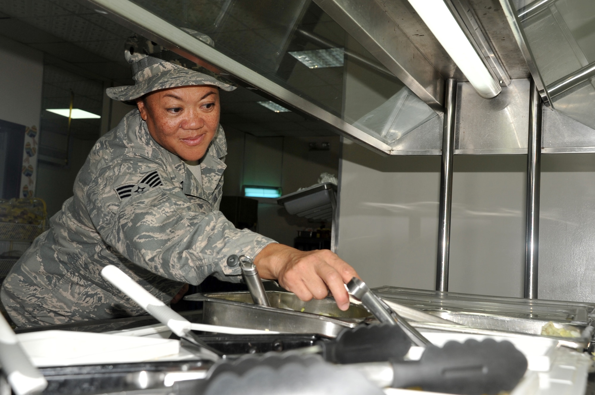 Tech. Sgt. Johnette Chun, a services craftsman assigned to the 380th Expeditionary Force Support Squadron, cleans the salad bar area at Roy's Flight Kitchen in the 380th Air Expeditionary Wing operations area at a non-disclosed base  in Southwest Asia on May 1, 2010. At her deployed location, she serves as the NCO in charge of the night shift of Roy?s Flight Kitchen. She is deployed from the Hawaii Air National Guard's 154th Force Support Squadron at Hickam Air Force Base, Hawaii, and her hometown is Lihue, Kauai, Hawaii. (U.S. Air Force Photo/Master Sgt. Scott T. Sturkol/Released)