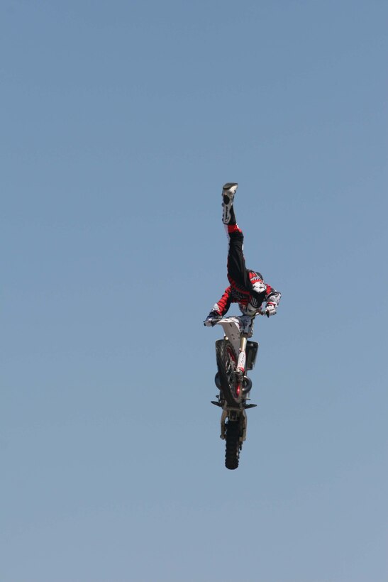 Matt Buyten, a professional freestyle Motocross rider, performs a stunt in mid-air after taking off from a large ramp outside the Marine Corps Exchange here May 3, 2010. The Motocross event was part of this year's MCX Retail Conference.