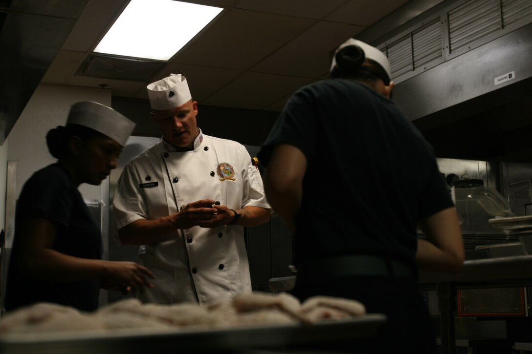 Sgt. Jonathan C. Duncan, 28, food service specialist 1st Food Service Co., Combat Logistics Regiment 17, 1st Marine Logistics Group, checks over the food just before the 14 area chow hall, Camp Pendleton, Calif., opens.