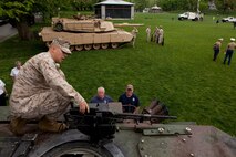Cpl. Brendan Faul, a Marine with Echo Company, 4th Tank Battalion, who's a native of Noblesville, Ind., shows a couple of Bostonian firefighters the mounted M2 .50 caliber machine gun on an M1A1 Abrams Main Battle Tanks May 3 at Boston Common. This exhibition was during the first day of Marine Week Boston, which honors and recognizes the contributions of Marines, including Boston-based hometown heroes and their families.