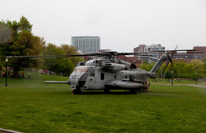 Staff Sgt. Alfredo J. Martinez, a Bethlehem, Pa., native serving with Marine Tiltrotor Test and Evaluation Squadron 22, a unit based out of Marine Corps Air Station New River, guides the pilot of an MV-22B Osprey as it comes to a landing at Boston Common May 3. Marines who crewed the aircraft exhibited the Osprey they flew in on during the first day of Marine Week Boston, which honors and recognizes the contributions of Marines, including Boston-based hometown heroes and their families.