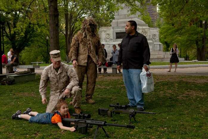 Nicholas Martin, a 4-year-old from Medford, Mass., lays down behind the scope of a M82 .50 caliber Special Application Scoped Rifle during an exhibition of weapons used by Marines at Boston Common May 3. The exhibition was during the first day of Marine Week Boston, which honors and recognizes the contributions of Marines, including Boston-based hometown heroes and their families.