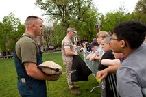 Cpl. Daniel Pierce, a native of Tyngsboro, Mass., and Sgt. Elijah Prudhomme, a native of Bartlesville, Okla., both military working dog handler with Military Police Support Company, 2nd Marine Aircraft Wing, Marine Corps Base Camp Lejeune, N.C., show children of Boston the protective gear they wear when training their military working dogs during a demonstration at Boston Common May 3. The demonstration was during the first day of Marine Week Boston, which honors and recognizes the contributions of Marines, including Boston-based hometown heroes and their families.