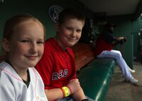 Jake and Shaelin Murphy, the son and daughter of Maj. Neil Murphy of New York City Public Affairs can't help but be happy to be sharing the bench with Red Sox designated hitter David Ortiz at Fenway Park May 3, 2010, just before they stepped up to their job as honorary bat boy and bat girl.