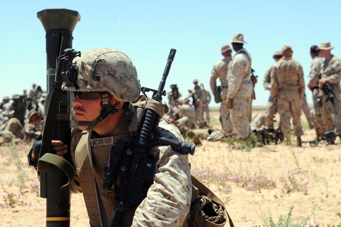 Rifleman Pfc. Luke Macarthur with Company B, 1st Battalion, 1st Marine Regiment, waits for his ride at Auxiliary Airfield 2, prior to beginning a helicopter-borne raid on a simulated insurgent camp in the Chocolate Mountains in California, May 3, 2010. Inserting in four different locations, via MV-22 Ospreys, CH-46 Sea Knights and CH-53 Super Stallions, Companies B and C, along with the Weapons Company, assaulted the camp with small-arms fire and rockets. Here supporting the current Weapons and Tactics Instructor course, the Camp Pendleton, Calif.-based unit is also training for a deployment early next year with the 13th Marine Expeditionary Unit.
