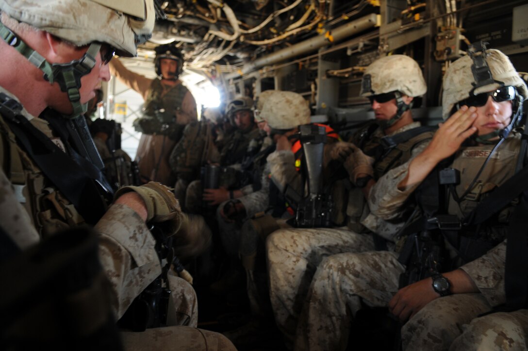 Marines with 1st Battalion, 1st Marine Regiment, settle into a MV-22 Osprey on their way to a helicopter-borne raid on a simulated insurgent camp in the Chocolate Mountains in California, May 3, 2010. Inserting in four different locations, via MV-22 Ospreys, CH-46 Sea Knights and CH-53 Super Stallions, Companies B and C, along with the Weapons Company, assaulted the camp with small-arms fire and rockets. Here supporting the current Weapons and Tactics Instructor course, the Camp Pendleton, Calif.-based unit is also training for a deployment early next year with the 13th Marine Expeditionary Unit.