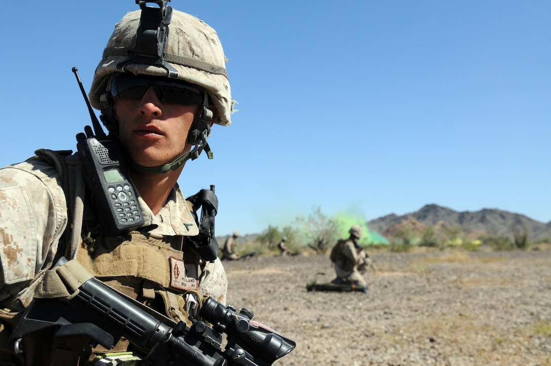Team leader Pfc. Shea Boland, with Company B, 1st Battalion, 1st Marine Regiment, looks down the line as smoke billows behind him, the signal for pick-up, during a helicopter-borne raid on a simulated insurgent camp in the Chocolate Mountains in California, May 3, 2010. Inserting in four different locations, via MV-22 Ospreys, CH-46 Sea Knights and CH-53 Super Stallions, Companies B and C, along with the Weapons Company, assaulted the camp with small-arms fire and rockets. Here supporting the current Weapons and Tactics Instructor course, the Camp Pendleton, Calif.-based unit is also training for a deployment early next year with the 13th Marine Expeditionary Unit.