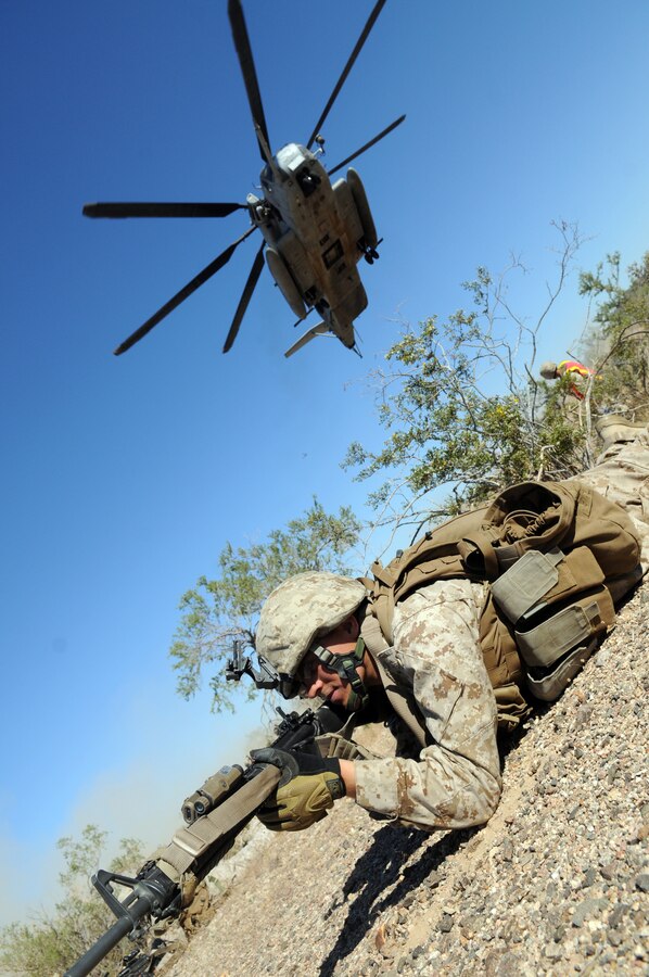 Rifleman Lance Cpl. Thomas Meikle, of Company B, 1st Battalion, 1st Marine Regiment, provides security as a CH-53 Super Stallion descends during a helicopter-borne raid in the Chocolate Mountains in California on May 3, 2010. Inserting in four different locations, via MV-22 Ospreys, CH-46 Sea Knights and CH-53 Super Stallions, Companies B and C, along with the Weapons Company, assaulted the camp with small-arms fire and rockets. Here supporting the current Weapons and Tactics Instructor course, the Camp Pendleton, Calif.-based unit is also training for a deployment early next year with the 13th Marine Expeditionary Unit.