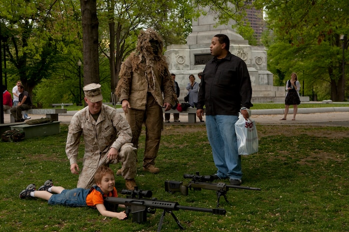 Nicholas Martin, a 4-year-old from Medford, Mass., lays down behind the scope of a M82 .50 caliber Special Application Scoped Rifle during an exhibition of weapons used by Marines at Boston Common May 3. The exhibition was during the first day of Marine Week Boston, which honors and recognizes the contributions of Marines, including Boston-based hometown heroes and their families.