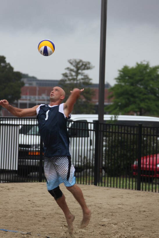 John Goings, first Navy beach team, serves a lofting shot during the beach volleyball tournament, May 4. Goings and the Navy men took silver in the indoor tournament and one of the two beach volleyball teams took gold.