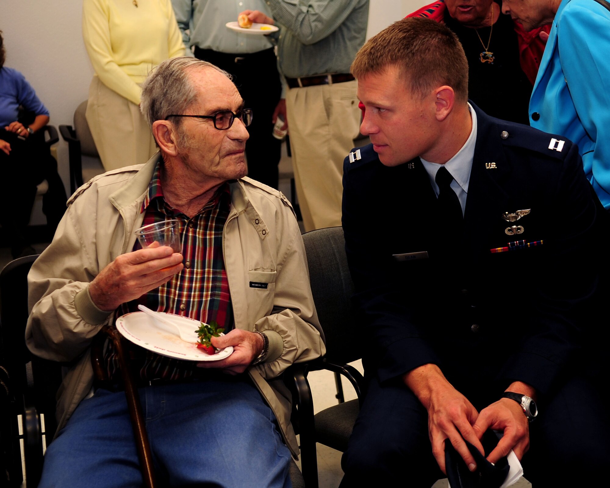 Capt. Joshua Dean, a pilot from the 354th Fighter Squadron, talks with Herb Schneider, a survivor of World War II and the Holocaust, during the Davis-Monthan Holocaust Day of Remembrance event at the Professional Development Center here May 3. Mr. Schneider was one of several survivors welcomed to D-M to share their stories of sacrifice and survival after WWII and the Holocaust, with our Airmen. This event was sponsored by the 355th Fighter Wing. (U.S. Air Force photo/Airman Jerilyn Quintanilla)