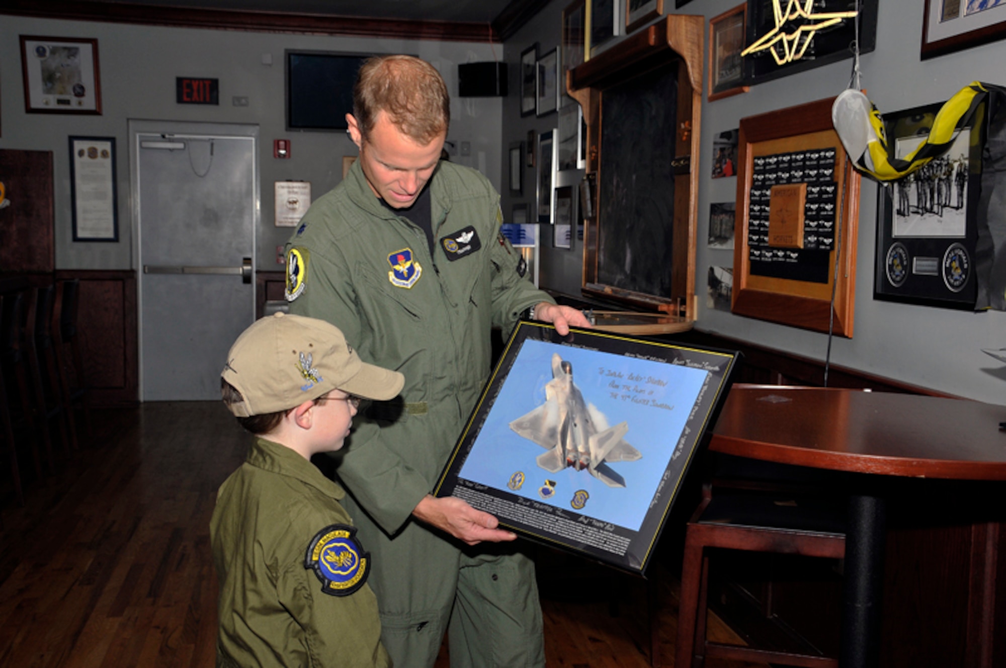 Lt. Col. Derek “Trapper” France, 43rd Fighter Squadron commander, presents an autographed F-22 lithograph to Jordan “Rocket” Shuman during his Pilot for a Day” visit to Tyndall AFB, Fla., April 30, 2010.