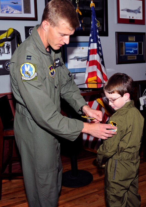 Capt. Scott “Omar” Bradley, 43rd Fighter Squadron instructor pilot, presents Jordan “Rocket” Shuman with a 325th Fighter Wing patch for his kid-size flight suit during his “Pilot for a Day” visit to Tyndall AFB, Fla., April 30, 2010.