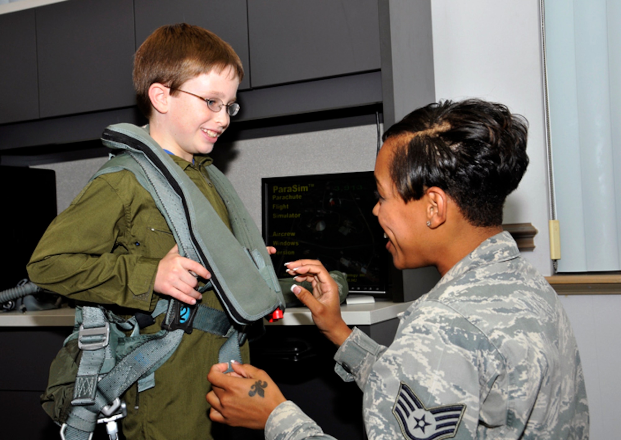 Staff Sgt. Adrian Williams, 325th Operations Support Squadron, helps Jordan “Rocket” Shuman with egress equipment as he prepares for his hanging harness training during his “Pilot for a Day” visit to Tyndall AFB, Fla.,  April 30, 2010.