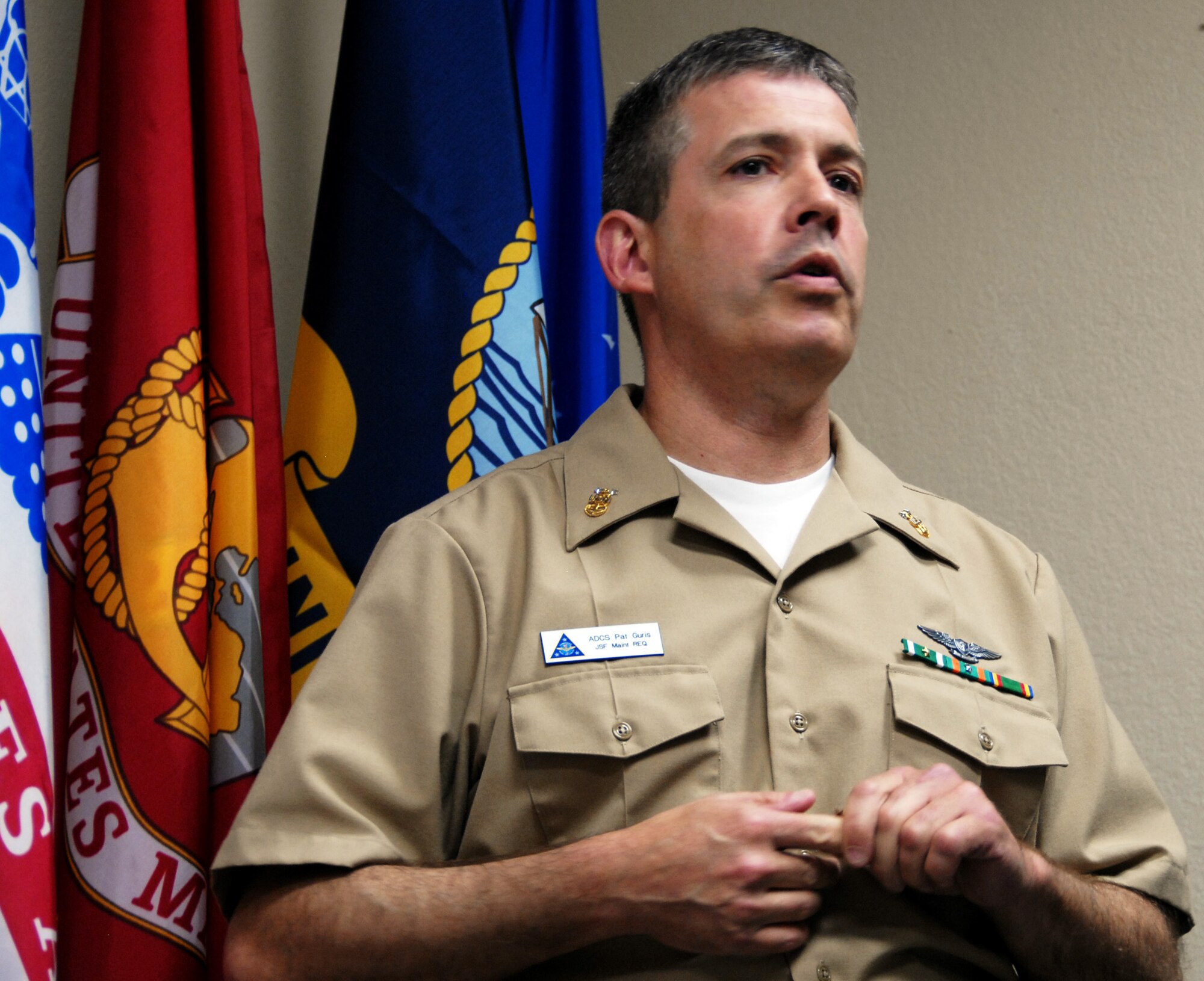 Master Chief Petty Officer Patrick Guris, F-35 Naval Fleet Integration Team, speaks to at the crowd of Sailors, Airmen and Marines who attended his promotion ceremony at the 33rd Fighter Wing. At the event, the 25-year veteran had the top Navy enlisted rate pinned on to his uniform by his son, Patrick, and Col. David Hlatky, 33rd FW commander. (Air Force photo/Ashley M. Wright)