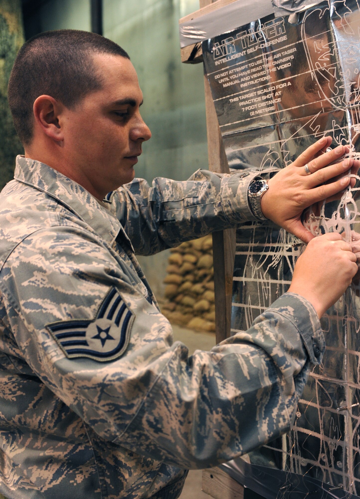 Staff Sgt. William Braden, 319th Security Forces Squadron, removes taser probes from a practice target on Grand Forks Air Force Base, N.D.  Sergeant Braden completed his annual certification on the Non-lethal Weapons System Course. (U.S. Air Force photo by Airman 1st Class Amber Price)