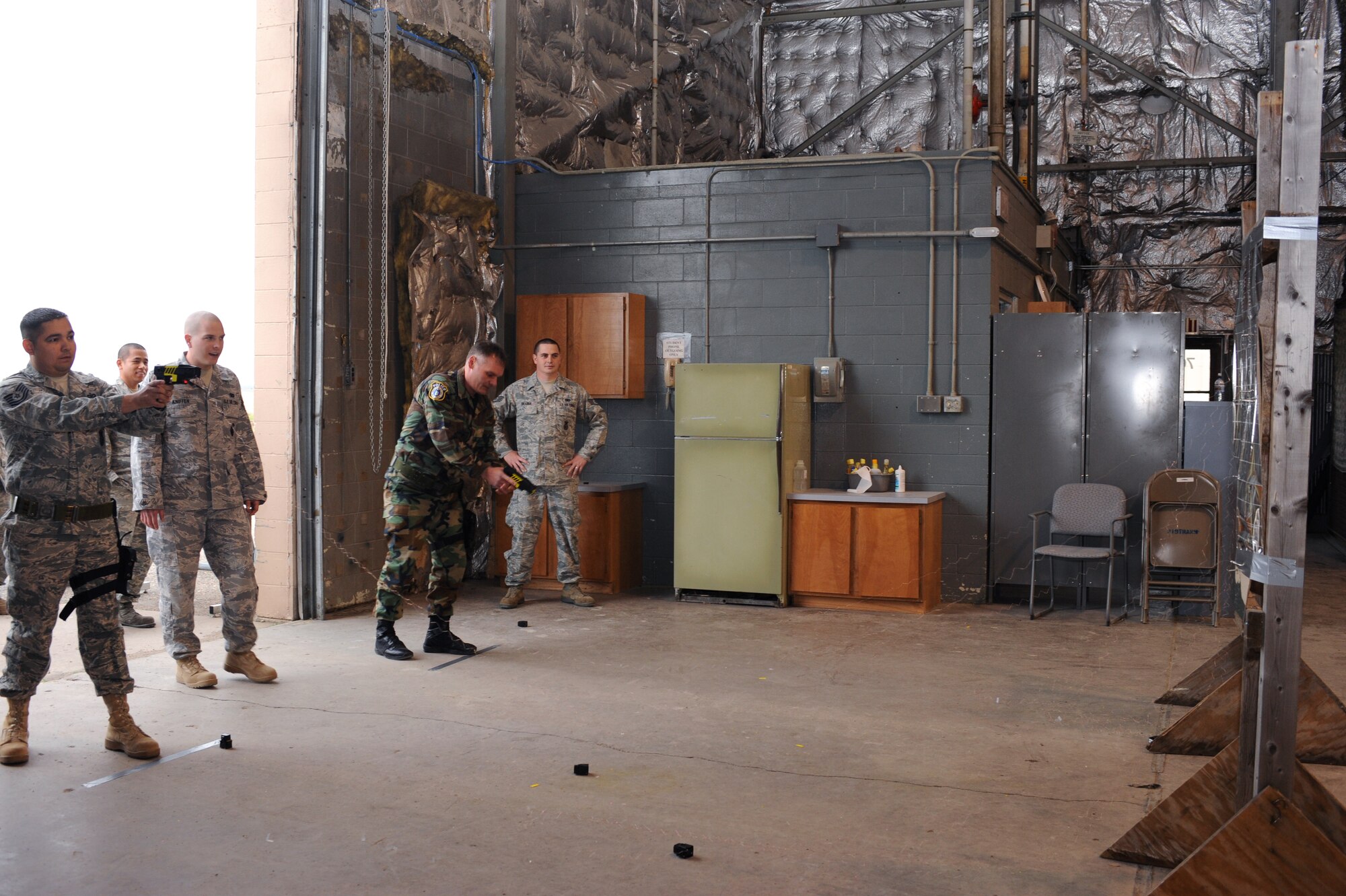 Tech. Sgt. Mark Ochoa (far left), 319th Security Forces Squadron, and Chad Sherod (3rd from left), 319th SFS patrolman, change taser cartridges on Grand Forks Air Force Base, N.D. Sergeant Ochoa and Patrolman Sherod receive instruction from Senior Airman Matthew Kniffen, 319th SFS (2nd to left). (U.S. Air Force photo by Airman 1st Class Amber Price)