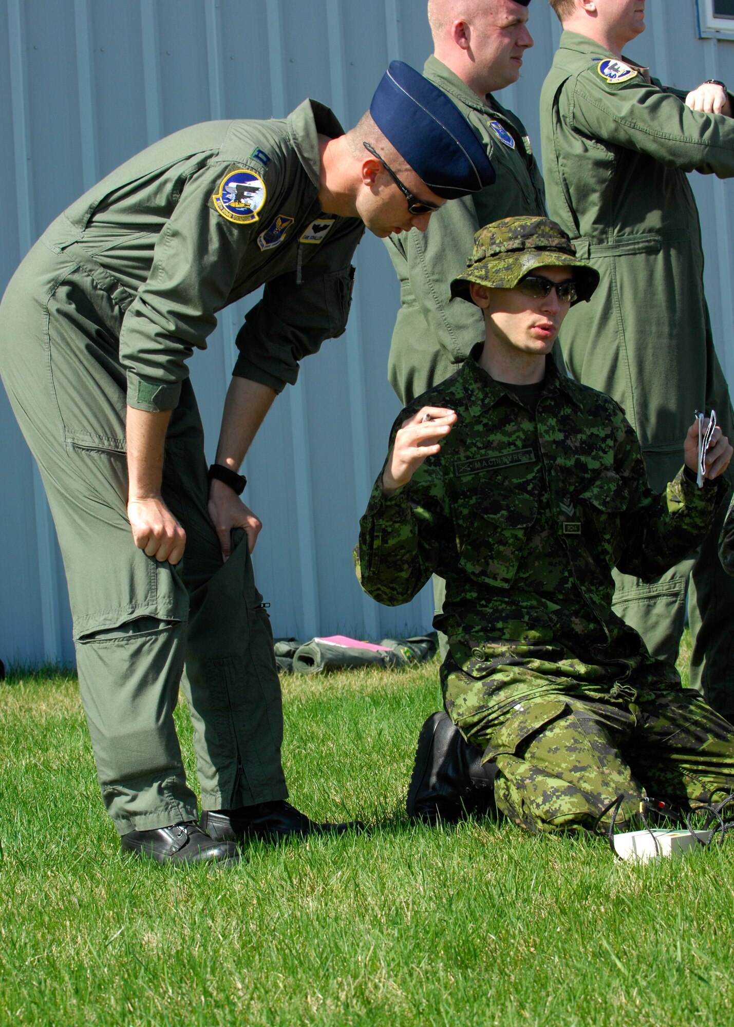 MINOT, N.D. -- Capt. Earl Schaller, 69th Bomb Squadron training flight assistant commander, and Master Bombardier Michael MacIntyre, member of the Canadian Forces Base Shilo, discuss training procedures during a Joint Terminal Attack Controller training held here April 27 and 28. The training was part of a joint effort to maintain proficiency and increase familiarization of both Canadian and American procedures. (U.S. Air Force photo by Senior Airman Ashley N. Avecilla)