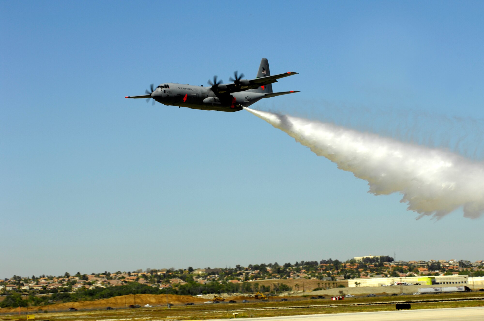 A C-130 releases a flood of water during a demonstration at the March Field AirFest, March Air Reserve Base, Calif., May 2, 2010. The AirFest is a bi-annual, two-day event featuring military and civilian aerial performances and static displays of modern and historic aircraft. (U.S. Air Force photo by Tech. Sgt. Carolyn Erfe/released)