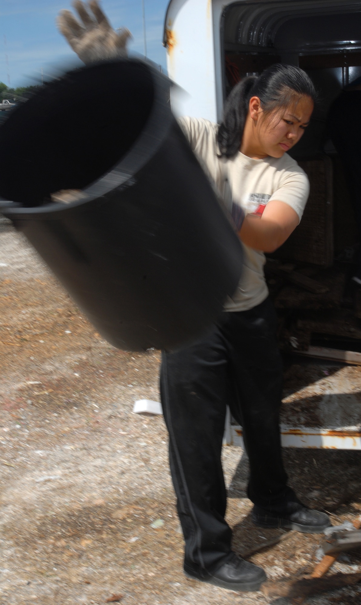 Airman 1st Class Junille Leon-Guerrero, 312th Training Squadron, unloads a trailer full of trash during the Great American Cleanup at the San Angelo Coliseum May 1.  Twice a year San Angelo and Keep San Angelo Beautiful, with the help of volunteers from Goodfellow, participate in the Great American Cleanup.   The community effort spans the country with the intent of reducing trash by recycling waste materials versus adding more material to local landfills. (U.S. Air Force photo/ Master Sgt Randy Mallard)