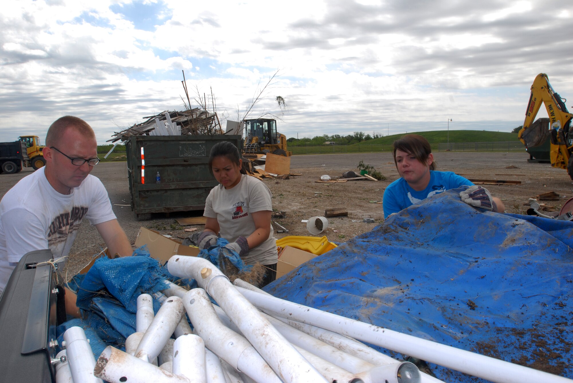 Senior Airman Daniel Letchworth, 17th Communications Squadron, Airman 1st Class Samantha Engeler, 312th Training Squadron, and Airman 1st Class Junille Leon-Guerrero, 312th Training Squadron, unload a pick up bed full of cardboard boxes during the Great American Cleanup at the San Angelo Coliseum May 1.  Twice a year San Angelo and Keep San Angelo Beautiful, with the help of volunteers from Goodfellow, participate in the Great American Cleanup.  The community effort spans the country with the intent of reducing trash by recycling waste materials versus adding more material to local landfills. (U.S. Air Force photo/ Master Sgt Randy Mallard)