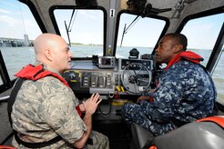 U.S. Navy Lt. Marvin Robinson navigates a harbor security boat on the Cooper River while U.S. Air Force Lt. Col. Stevan Kaighen talks about Joint Base Charleston issues between logistics readiness squadron and port operations  April 29, 2010, at Naval Weapons Station, S.C. Colonel Kaighen was at the NWS to do his "Welcome Aboard Skipper" tour to meet sailors, promote team integration as well as familiarize himself with their facilities and responsibilities. Colonel Kaighen is the commander for the 628 LRS and Lieutenant Robinson is the Port Operations Officer and soon to be 3rd in command at LRS.