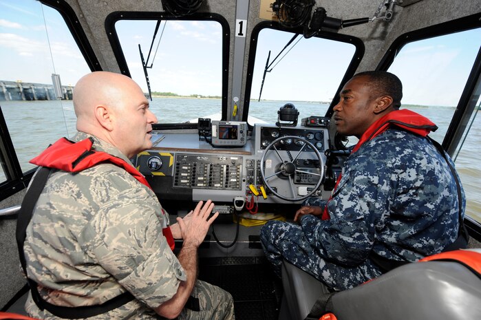 U.S. Navy Lt. Marvin Robinson navigates a harbor security boat on the Cooper River while U.S. Air Force Lt. Col. Stevan Kaighen talks about Joint Base Charleston issues between logistics readiness squadron and port operations  April 29, 2010, at Naval Weapons Station, S.C. Colonel Kaighen was at the NWS to do his "Welcome Aboard Skipper" tour to meet sailors, promote team integration as well as familiarize himself with their facilities and responsibilities. Colonel Kaighen is the commander for the 628 LRS and Lieutenant Robinson is the Port Operations Officer and soon to be 3rd in command at LRS.